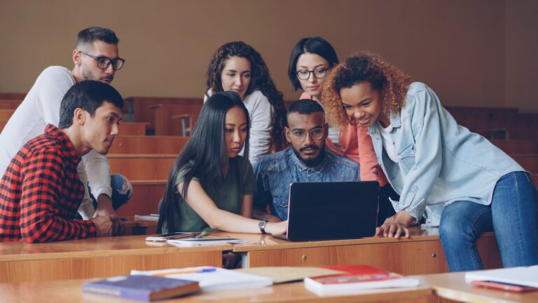 Students discussing laptop